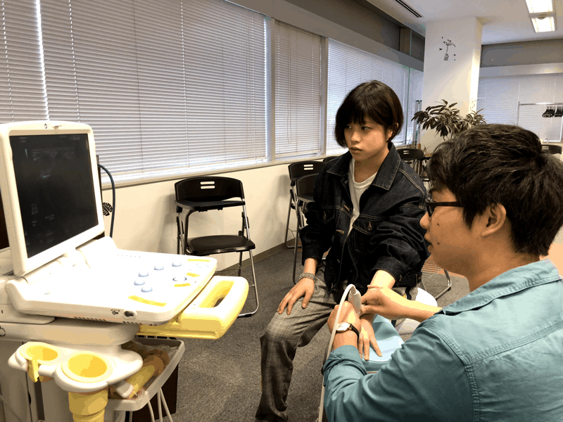 超音波画像診断装置のセミナーで、装置の使い方を練習する長尾先生と小俣先生の写真