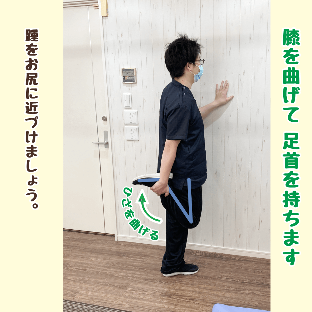 （ステップ2）右ひざを曲げて右足首を持ち、踵をお尻に近づけている大腿四頭筋ストレッチの途中の様子