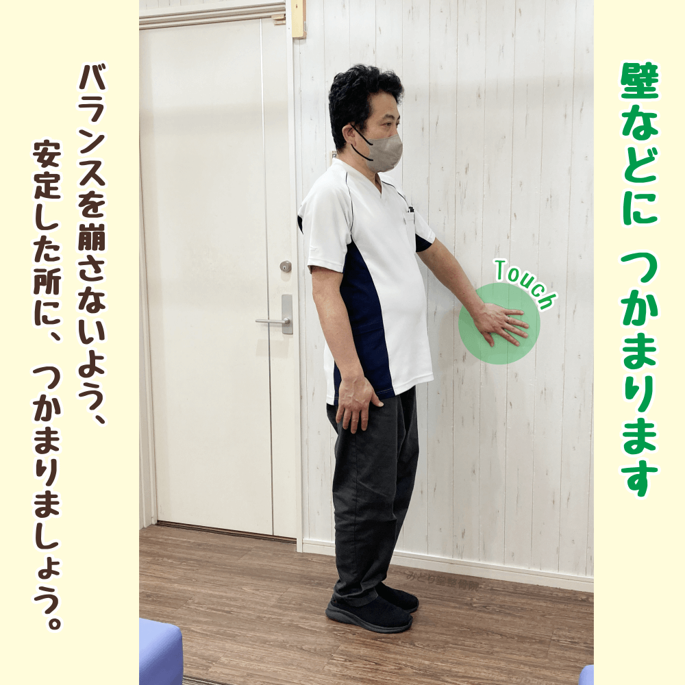 壁や手すりにつかまり立って四頭筋ストレッチの準備をする姿勢