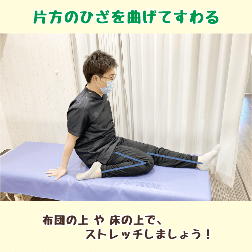 下り階段で負担がかかる筋肉のセルフケアストレッチ・工程1。ベッドに座り、右膝を曲げて左足を伸ばした準備姿勢。
