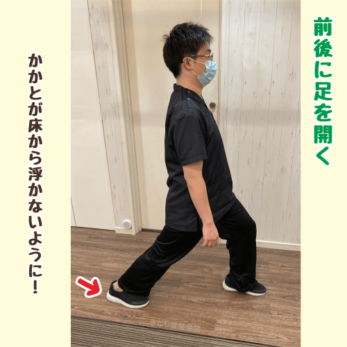 ストレッチ工程2。足を前後に開き、左足を前、右足を後ろにした姿勢。