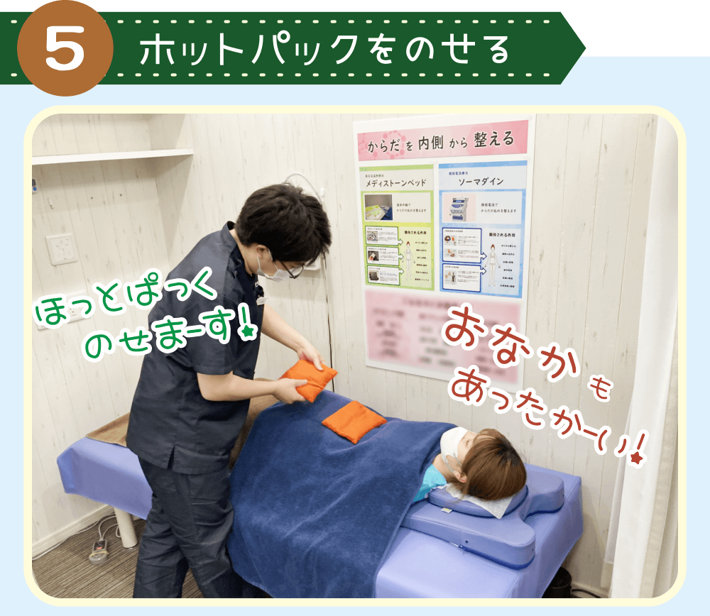 佐藤の腹部にホットパックをのせるシーン。お腹からも温められ、佐藤は気持ちよさそうな表情